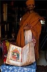 A priest at Kebran Gabriel Church shows one of its many ancient illustrated books; the church has the largest library in the Tana region.