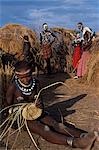 A Nyangatom girl weaves a grass basket. The Nyangatom or Bume are a Nilotic tribe of semi-nomadic pastoralists who live along the banks of the Omo River in south-western Ethiopia.