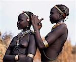 A Dassanech girl braids her sister's hair at her village in the Omo Delta. Much the largest of the tribes in the Omo Valley numbering around 50,000,the Dassanech (also known as the Galeb,Changila or Merille) and Nilotic pastoralists and agriculturalists.