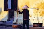 Woman carrying Vine leaves to early morning market