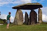 Au Royaume-Uni, pays de Galles, Pembrokeshire. Un jeune garçon visite le site de l'ancien dolmen néolithique de Pentre Ifan, des célèbres mégalithes du pays de Galles, les restes d'un vaste tumulus celtique.