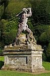 Wales; Powys; Welshpool. Statue of Hercules killing the Hydra against the backdrop of a massive yew hedge in the spectacular garden at Powis Castle