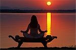 Zambia,Lower Zambezi National Park. Yoga on a saddle bench watching the sun go down across the Zambesi River