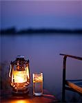 Zambie, Lower Zambezi National Park, Old Mondoro Bushcamp. Gin and tonic par la lumière d'une lampe-tempête ; donnant sur le fleuve Zambèze.