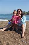 Portrait of Mother and Baby Daughter Sitting on Beach, Fogarty Creek State Park, near Depot Bay, Oregon, USA