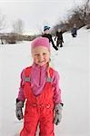 Fille dans la neige avec les frères derrière elle, Steamboat Springs, Colorado, USA