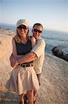 Paar auf einen Bluff vom Pazifischen Ozean bei Sonnenuntergang, in der Nähe von Santa Cruz, Kalifornien, USA