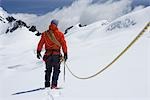 Wanderer, die mit Sicherheit-Linie in den schneebedeckten Bergen, Rückansicht verbunden