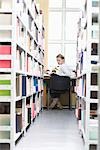 Young woman sits at desk in library