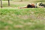 Woman lying on grass, daydreaming