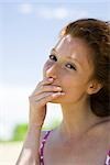 Young woman covering mouth with hand, portrait