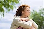 Young woman outdoors, looking away in thought