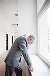 Businessman leaning against window