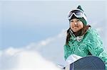 Woman Sitting  on Snowfield with Snowboard