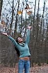 Woman Throwing Autumn Leaves in the Air