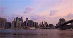 Brooklyn Bridge spanning the East River and the Lower Manhattan skyline at dawn, New York City, New York, United States of America, North America