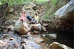 Kinder auf den Felsen am Fluss