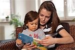 Teenage Girl Reading Book to Little Boy, Mannheim, Baden-Wurttemberg, Germany