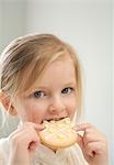 Kleine Mädchen essen einen Oster-Cookie