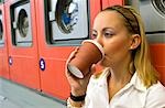 Femme buvant café dans la laverie