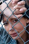 Woman Crying behind Fence