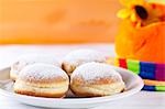 Doughnuts on a plate in front of a colourful hat, close-up