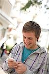 Young man using mp3-player, low angle view