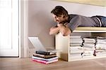 Man lying on a shelf and looking at a notebook, low angle view