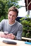 Young man using mobile phone, low angle view