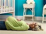 Pregnant older woman lying on floor