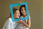 Girls looking through picture frame