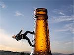 Businessman Climbing up Beer Bottle