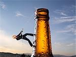 Businesswoman Climbing up Beer Bottle