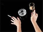 Female hand with cigarette in holder and glass of champagne