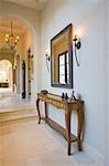 Antique console table with grey framed mirror in hallway