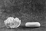 Gros plan d'une barre de savon avec perles pour le bain dans un bol