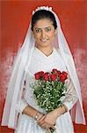 Portrait of a newlywed bride holding a bouquet of flowers and smiling