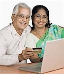 Senior man and a mature woman shopping online