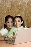 Mature woman using a laptop with her granddaughter