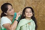 Femme mature, peigner les cheveux de sa petite-fille
