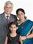 Girl standing with her grandparents and smiling