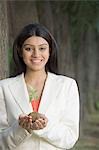 Portrait of a businesswoman holding a plant and smiling