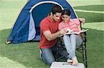 Couple reading a magazine in a park