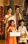 Children holding gifts with their parents holding religious offering