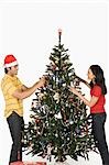 Couple decorating a Christmas tree and smiling