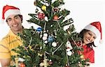 Portrait de la lecture d'un couple à travers un arbre de Noël