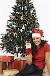 Portrait of a woman showing a Christmas stocking and smiling