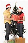 Couple holding a Christmas present and smiling