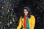 Woman standing in snow near a Christmas tree