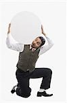 Businessman carrying a blank circular placard